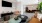 a clubhouse room with a tv, chairs and tables